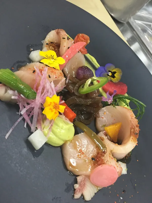Seafood crudo with edible flowers, plated by Chef Kimberly